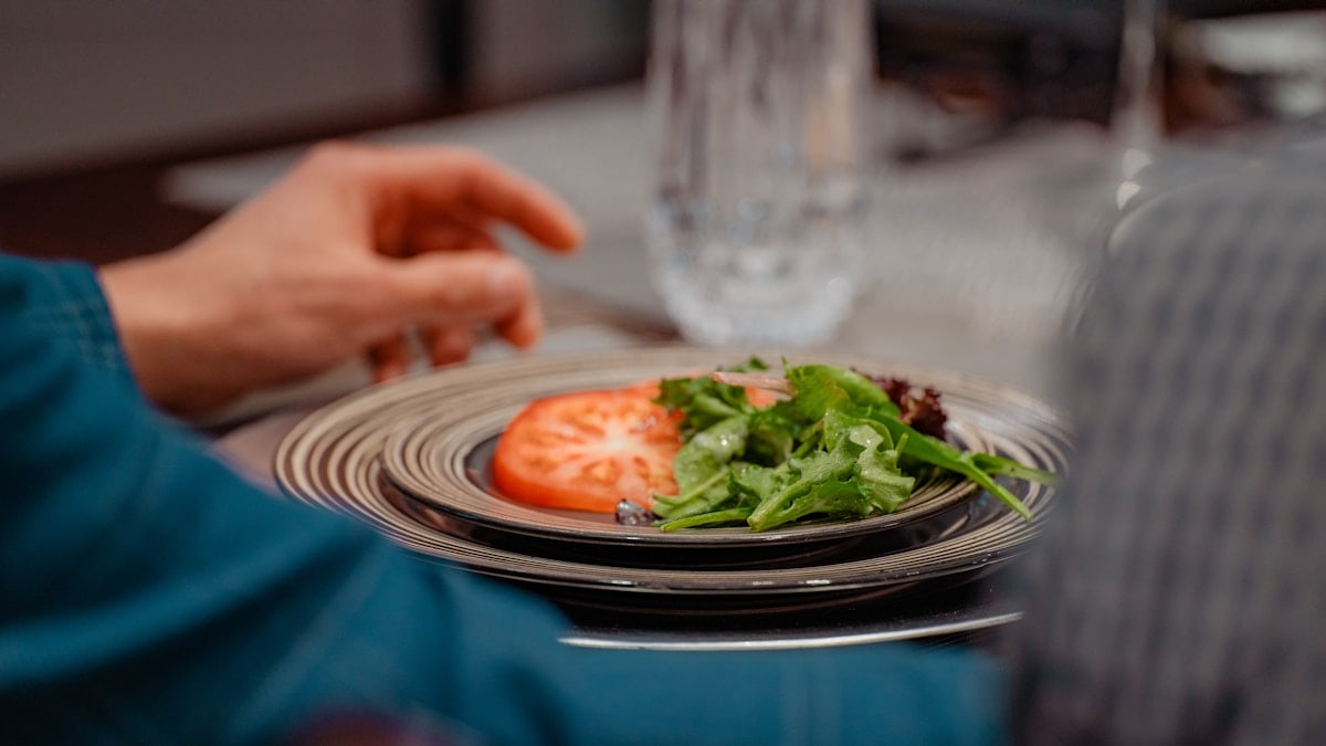 a person sitting at a table with a plate of food